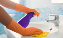 woman doing chores cleaning bathroom at home